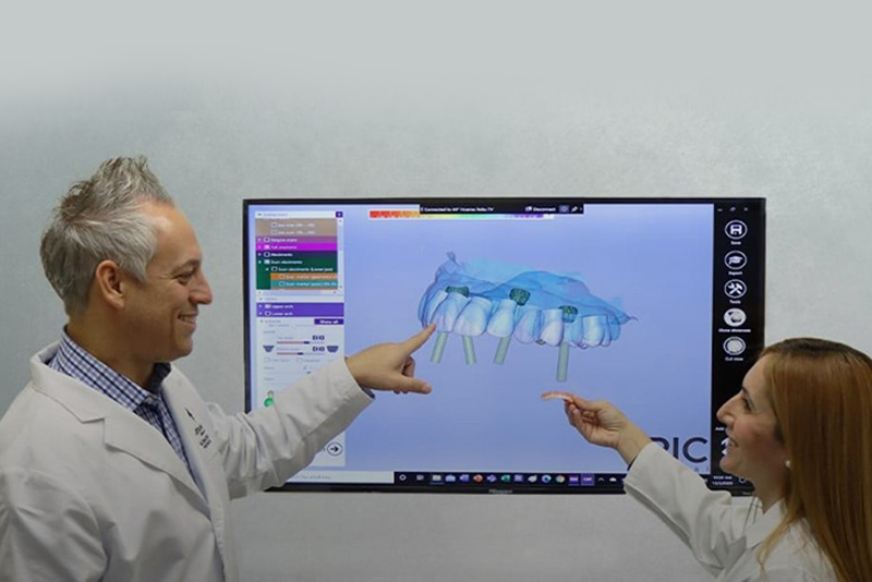 image within the dental practice of the Dr. and assistant looking at display model
