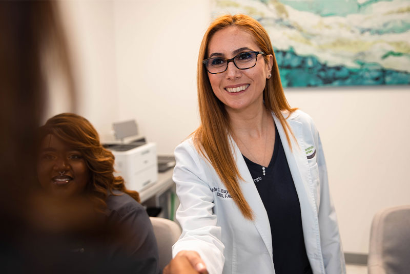 Dr. shaking hands with patient after dental procedure